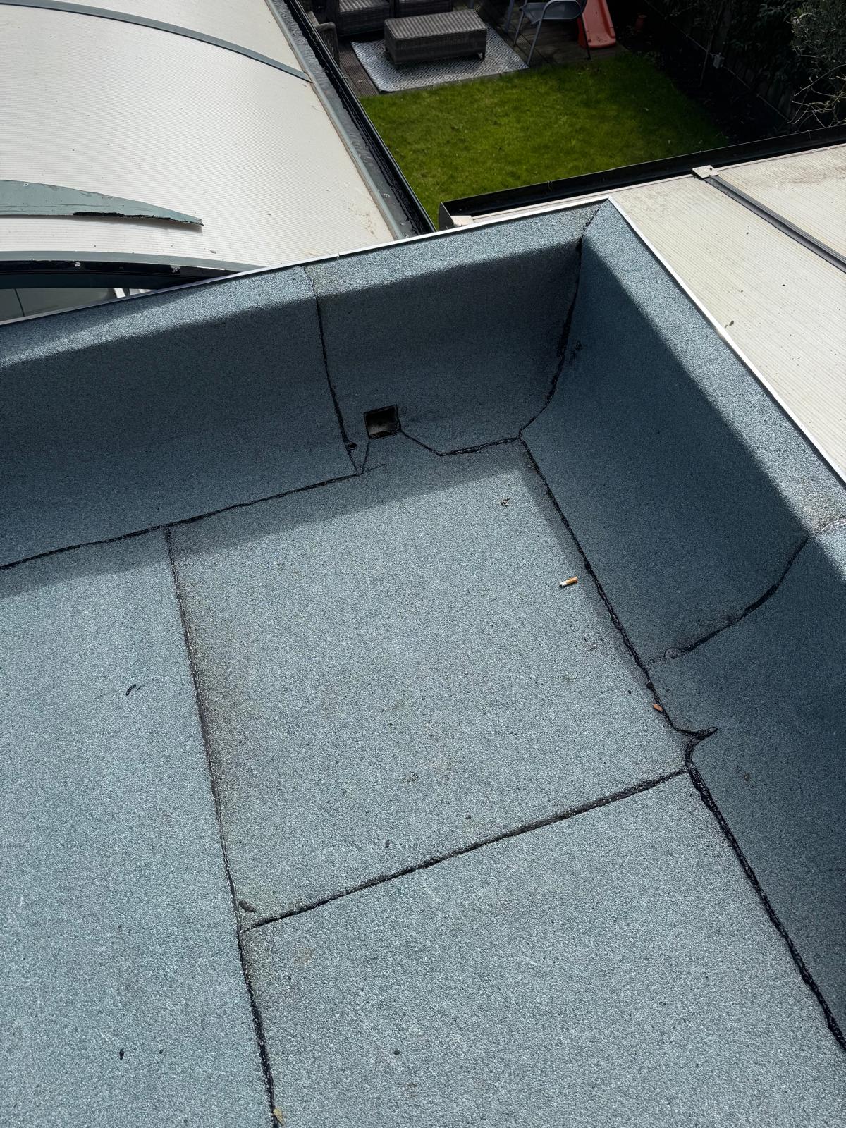 Nieuwe bitumen dakbedekking bij de dakrand en hemelwaterafvoer in Rosmalen