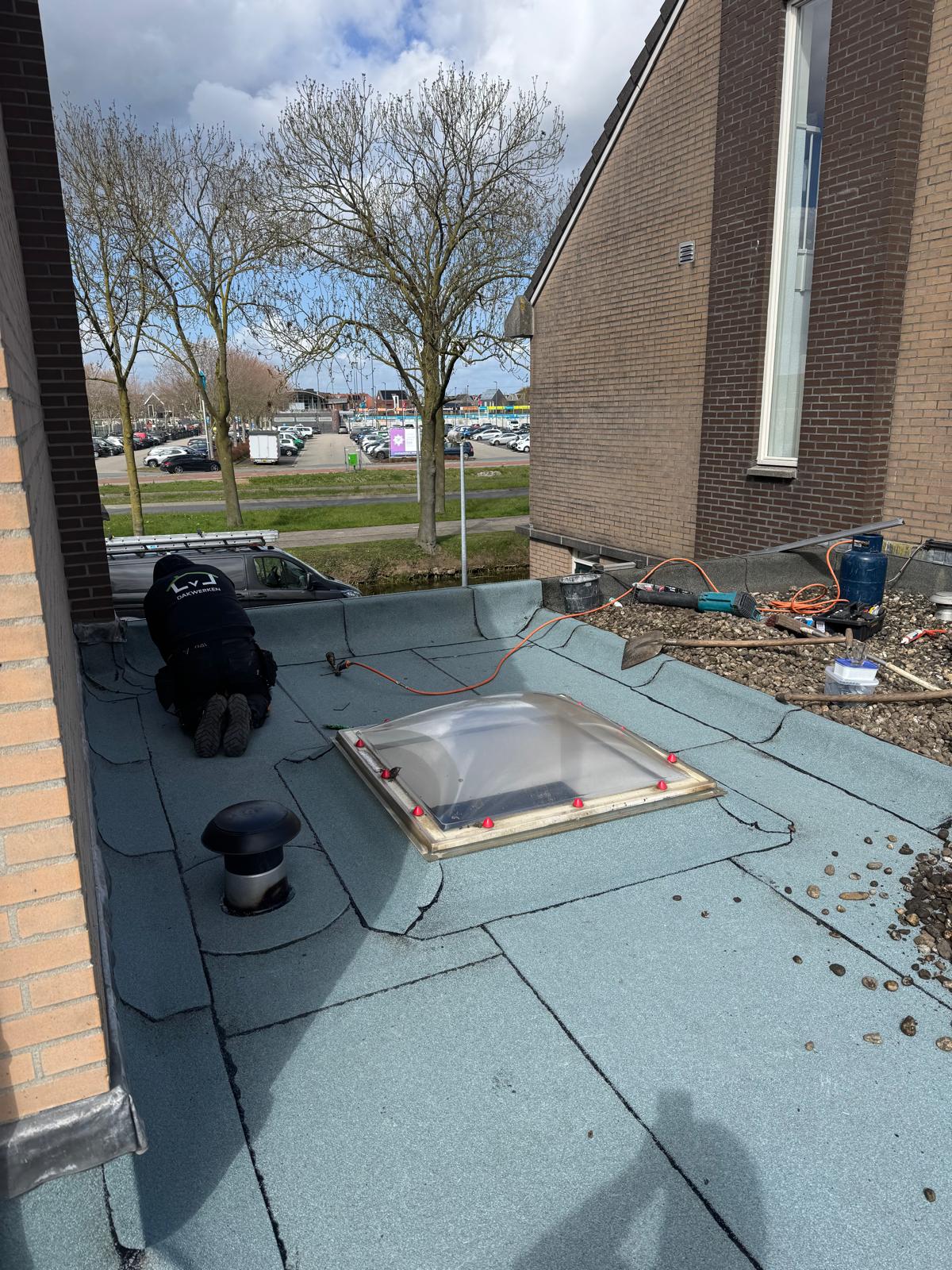 Aanbrengen van bitumen dakbedekking rond de lichtkoepel en dakdoorvoer in Rosmalen