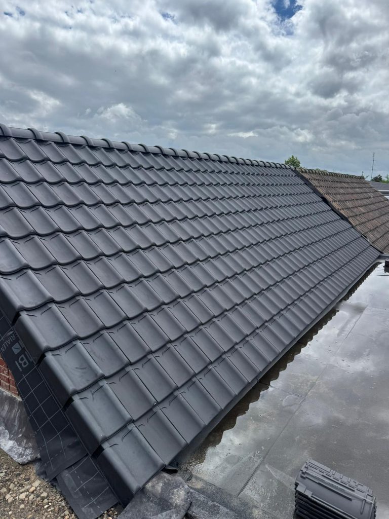 Blauw gesmoorde keramische dakpannen op het vernieuwde dak in Boxtel