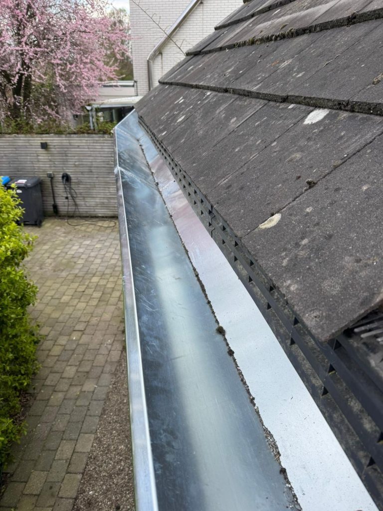 Nieuw geplaatste zinken goot langs het dak